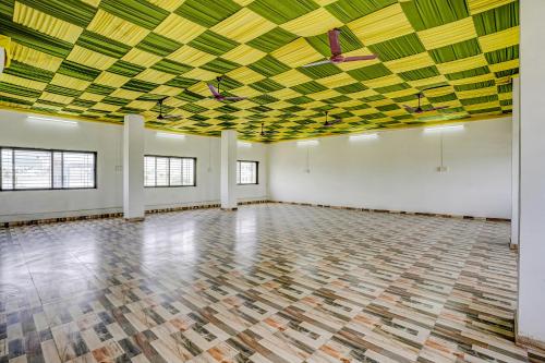 an empty ballroom with a yellow and green ceiling at FabHotel Ansh in Aurangabad