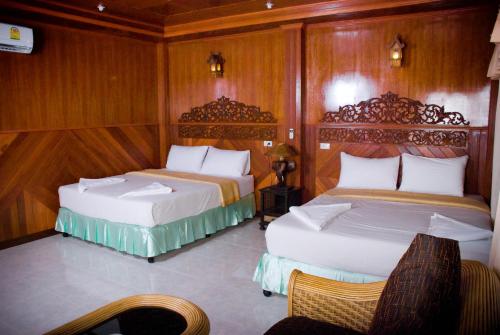 due letti in una stanza con pareti in legno di Dreamland Resort a Thong Nai Pan Yai