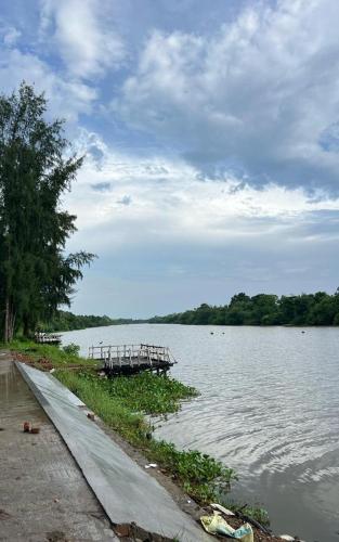 a dock in the middle of a body of water at Damodar River Retreat, Uluberia in Uluberiya