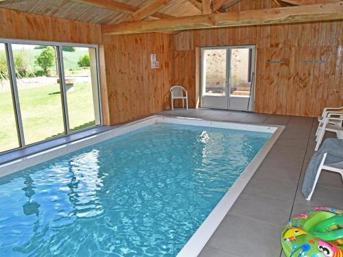 - une grande piscine dans une maison dotée de fenêtres dans l'établissement Gîte rénové avec piscine intérieure, accessible PMR, en plein cœur du Bocage Vendéen. - FR-1-426-536, à Cheffois