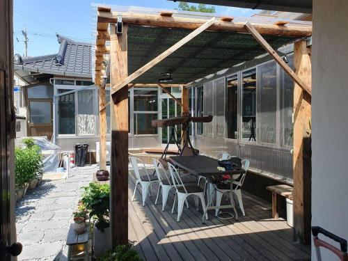 une terrasse avec une table et des chaises dans une maison dans l'établissement Daepung Stay, à Andong