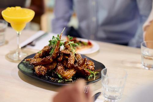 a plate of meat on a table with a drink at Mercure Darwin Airport Resort in Darwin