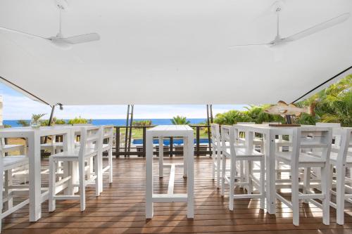 einen Balkon mit weißen Stühlen, Tischen und Meerblick in der Unterkunft The Beach House by Anglers Choice in Dundee Beach