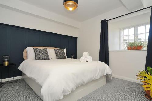 a bedroom with a large bed with a black headboard at Stylish apartment, Barbican in Plymouth