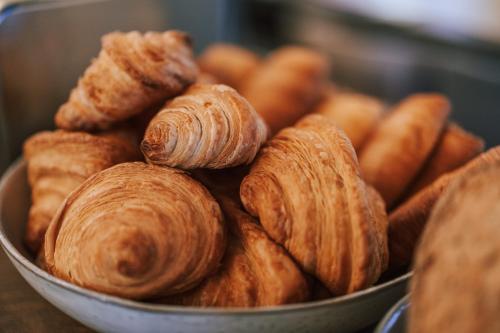 a metal bowl filled with croissants and carrots at Hotel Fiescherblick in Grindelwald