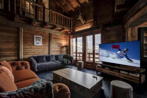 a living room with a flat screen tv in a cabin at Chalet Alaska in La Tzoumaz