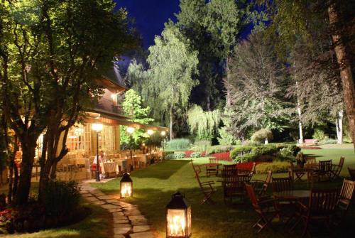 a garden with tables and chairs at night at Hotel de la Gaichel in Eischen