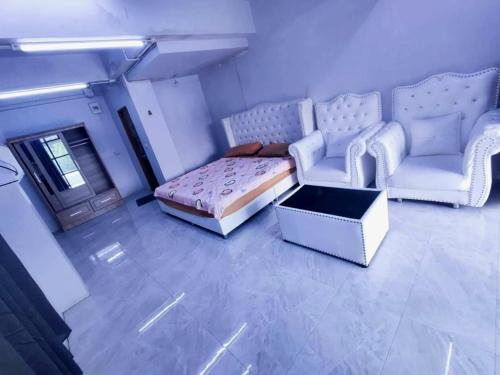 a living room with a couch and a bed and chairs at SUKANO Apartment VIP in Ban Thap Nang