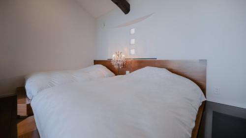 a bedroom with two white beds and a chandelier at Fugaku Gunjo in Izu