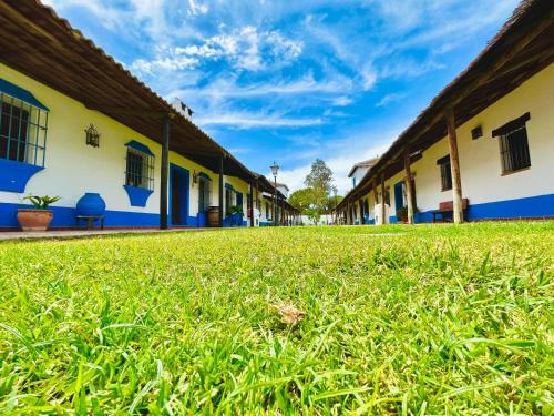 a row of buildings with grass in the foreground at Casa La Retama - Pequeño Rocio in El Rocío