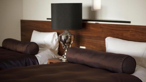 a hotel room with two beds and a lamp at Fugaku Gunjo in Izu