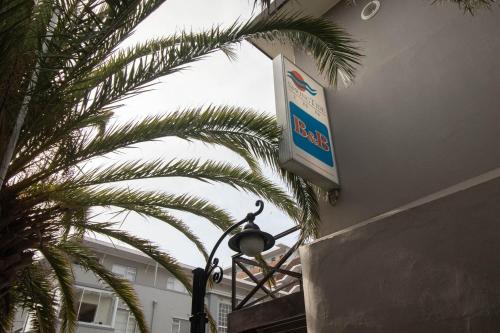 a street light with a sign on the side of a building at Spring Tide Inn by CTHA in Cape Town