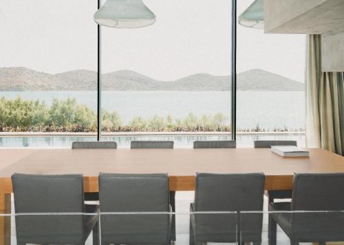 エロウンダにあるElounda Gulf Sunrise Villaの大きなテーブルと椅子付きの会議室を利用できます。