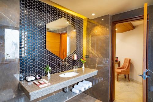 a bathroom with a sink and a mirror at Inde Signature Jaipur in Jaipur