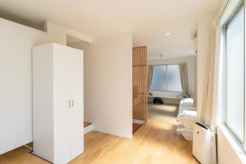 a room with a white closet and a window at Flower Base Lily House in Fukuoka