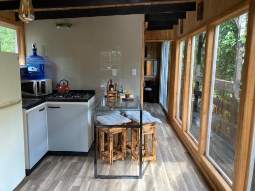 a kitchen with a counter with a table in it at Lodge in the Woods in Puerto Montt