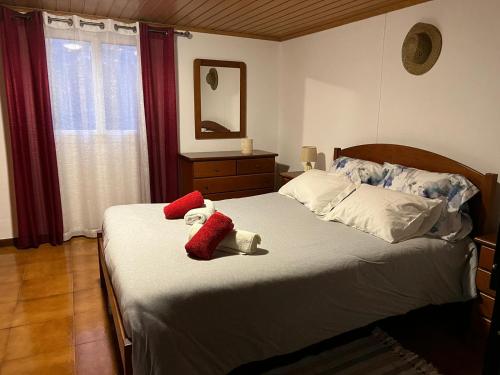 een slaapkamer met een bed met twee knuffels erop bij Vivenda Ribeiro - Curral das Freiras in Curral das Freiras