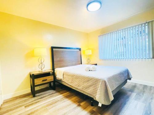1 dormitorio con 1 cama, 2 lámparas y ventana en 1BD1BR Downtowm San Jose free parking Laundry AC, en San José