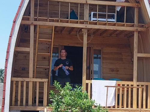 a man standing in the doorway of a house at Raturinjani homestay in Selong