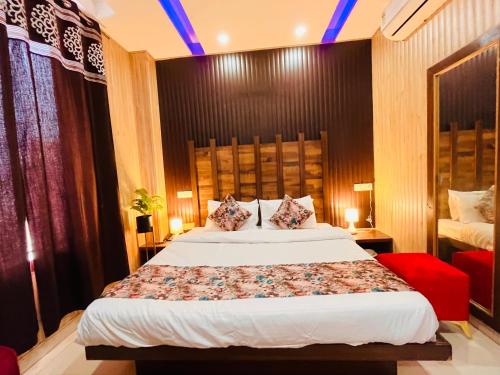 a bedroom with a large bed and a red chair at Hotel Pearl Grand, Zirakpur - Top Rated & Most Awarded Property in Tricity in Chandīgarh