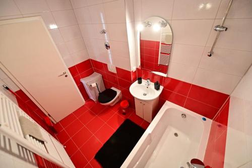 a red and white bathroom with a toilet and a sink at Shine in Sibiu in Şelimbăr