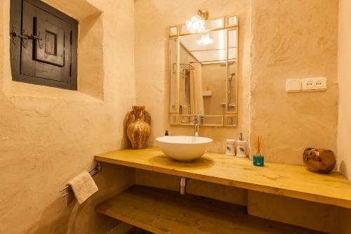 uma casa de banho com um lavatório num balcão de madeira em Masia del siglo xvi em Vallbona