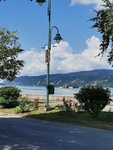 a street light with a sign on it next to a beach at Apartmani Pinkum in Veliko Gradište