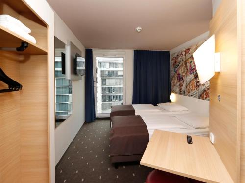 um quarto de hotel com duas camas e uma janela em B&B HOTEL Berlin-Alexanderplatz em Berlim