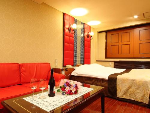 a hotel room with a couch and two beds at Restay Niigata (Adult Only) in Niigata