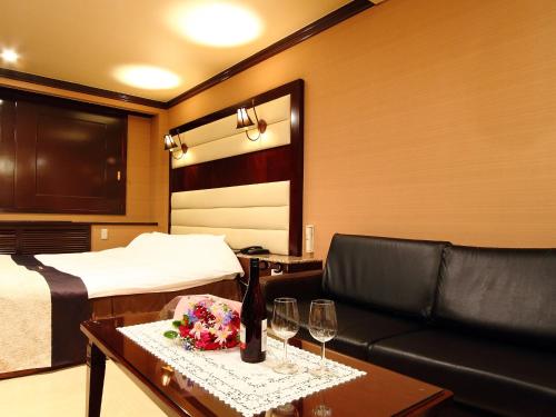 新瀉的住宿－新潟雷斯代酒店（僅限成人），一间酒店客房,配有沙发、床和酒杯