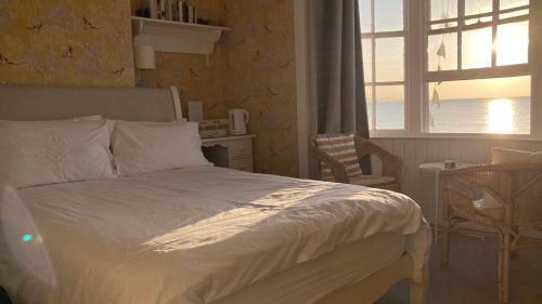 a bedroom with a bed and a window and a table at Whitecliff Guest House in Weymouth