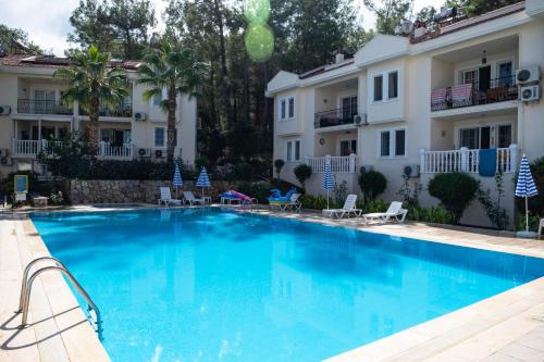 a large swimming pool in front of a building at 2BR Apartment in Ölüdeniz with Large Pool in Quiet Area in Fethiye