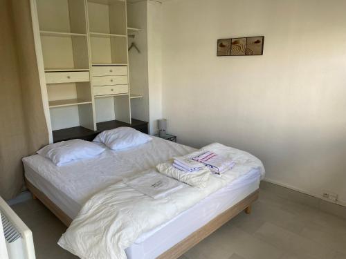 een slaapkamer met een bed met handdoeken erop bij Résidence About Malo RDC avec jardin lumineux à 2 pas de la plage in Duinkerke