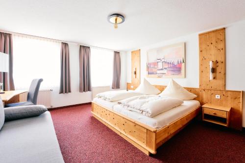 ein Schlafzimmer mit einem großen Bett mit weißen Kissen in der Unterkunft Blochums Gasthof Hirsch in Marktoberdorf