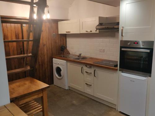 uma cozinha com uma máquina de lavar roupa e uma máquina de lavar roupa em The Forge Kington St Michael em Chippenham