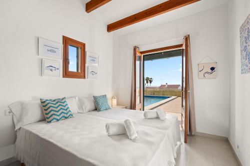 um quarto com duas camas e uma porta para uma piscina em Villa Michaela em Sant Lluis