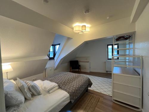een slaapkamer op zolder met een bed en een trap bij Kleines, feines Apartment in historischer Burg in Schlitz in Schlitz