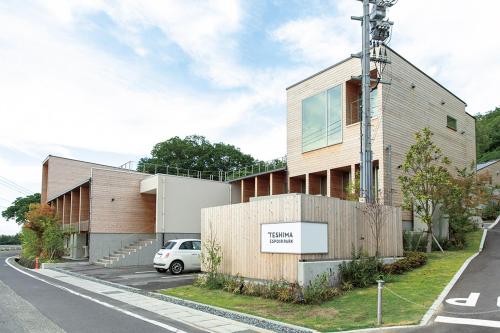 a building with a car parked in front of it at Teshima ESPOIR PARK in Ieura