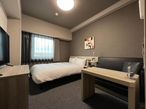 加東市にあるHotel Route Inn Katoのベッドとテレビが備わるホテルルームです。