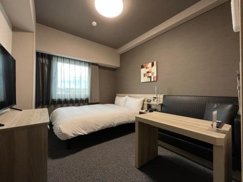 a hotel room with a bed and a television at Hotel Route Inn Kato in Kato