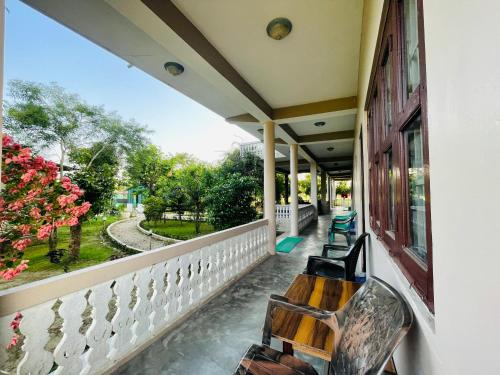 a porch with a bench and a view of a park at Hotel Tree Tops- A Serene Friendly Hotel in Sauraha in Chitwan
