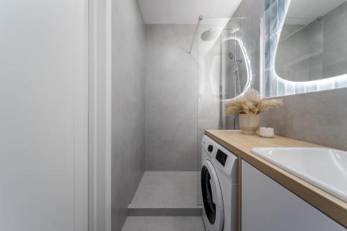 a bathroom with a washing machine and a sink at 77 views apartments by INSHI in Lviv