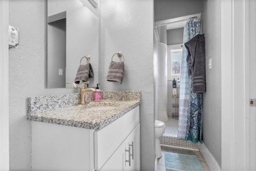 a white bathroom with a sink and a toilet at Navarre Apartments in Des Moines