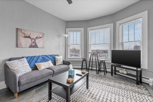 a living room with a couch and a flat screen tv at Navarre Apartments in Des Moines