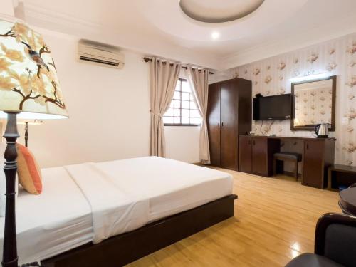 a bedroom with a bed and a desk in a room at Little Brick Saigon Hotel in Ho Chi Minh City
