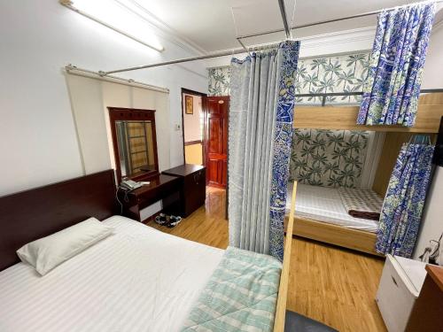 a bedroom with a bed and a desk and a mirror at Little Brick Saigon Hotel in Ho Chi Minh City