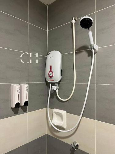 a shower in a bathroom with a hose on a wall at Kuching Apartment @ TT3 SOHO Near NorthBank in Kuching