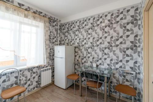 Una cocina con refrigerador y una mesa y sillas. en Kvartirkoff na Obolonskiy prospekt 31, en Kiev
