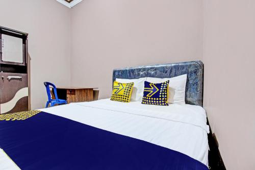 a bedroom with a large bed with yellow and blue pillows at SPOT ON 92373 Kristin Homestay 2 in Pati