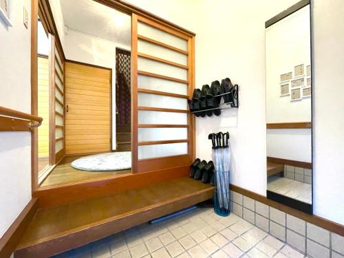 a room with a shower with a bench and a window at guesthouse森之宮【青丸】 in Osaka
